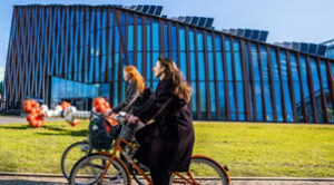 Hoofdkantoor van New Energy Coalition in Groningen; de Energy Academy Europe met twee studenten die voorbij fietsen.