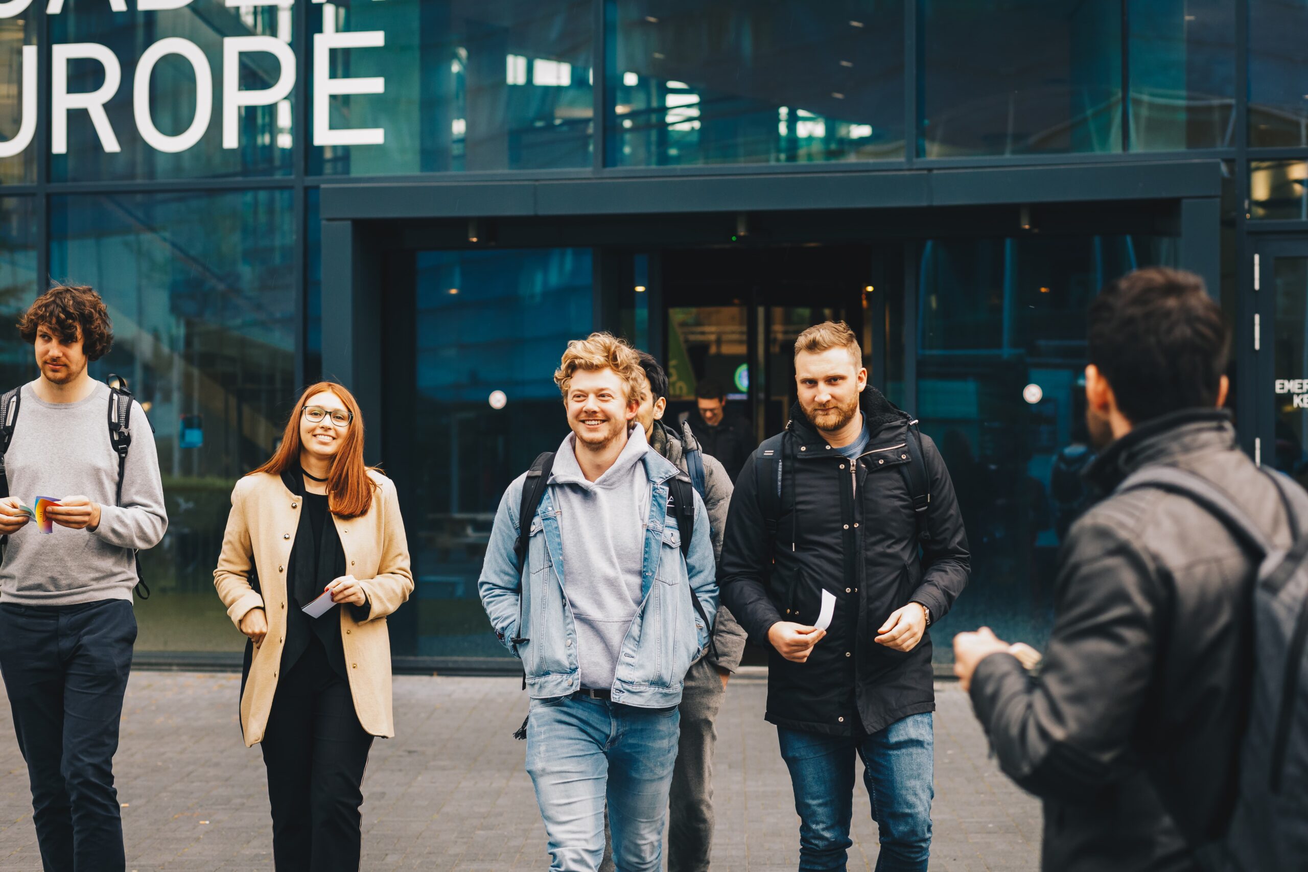 Foto van 4 studenten die uit het Energy Academy Europe lopen tijdens het New Energy Career Event georganiseerd door New Energy Academy, merk van New Energy Coalition.